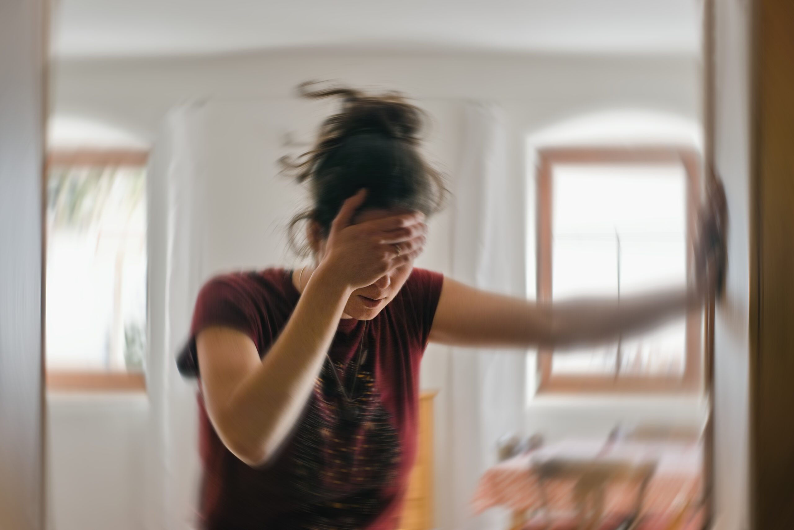 Blurred photo of woman showing signs of vertigo or dizziness. 