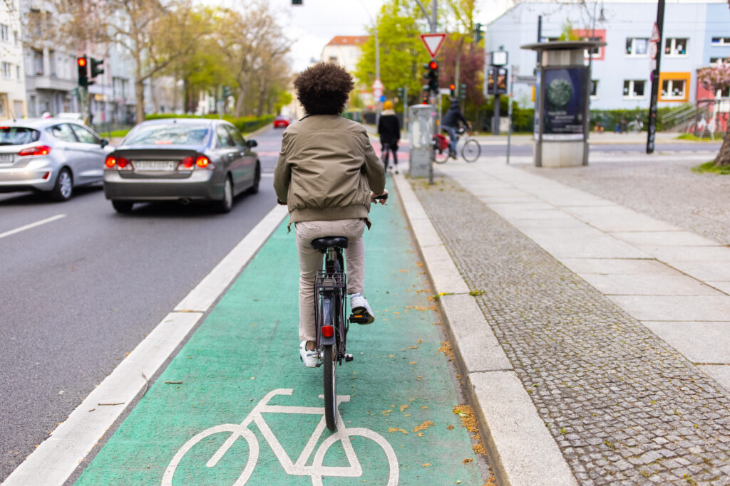 A man rides his bike using a bicycle lane.