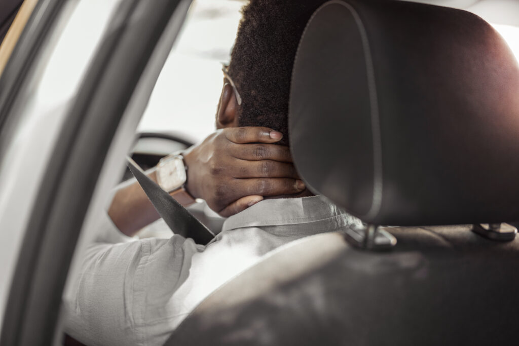 a man holding his neck after an auto accident.