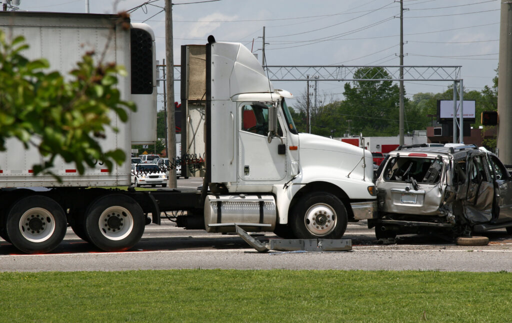 An accident between a semi-truck and a passenger minivan at an intersection. 